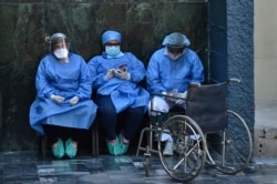 Health workers wear face masks and face shields against the spread of the new coronavirus at the Honduran Institute of Security in Tegucigalpa on March 31, 2020.