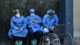 Health workers wear face masks and face shields against the spread of the new coronavirus at the Honduran Institute of Security in Tegucigalpa on March 31, 2020.