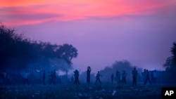 Displaced people who fled the recent fighting between government and rebel forces in Bor by boat across the White Nile, prepare to sleep in the open at night in the town of Awerial, South Sudan, Jan. 1, 2014.