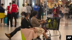 People shop in a mall, in Johannesburg, South Africa, Friday Nov. 26, 2021. Advisers to the World Health Organization are holding a special session Friday to flesh out information about a worrying new variant of the coronavirus that has emerged in South Africa.