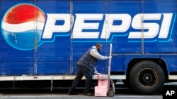 FILE - In this Feb. 9, 2012 file photo, Kandral McKenzie delivers Pepsi products in New York. PepsiCo reports quarterly earnings Wednesday, Oct. 16, 2013. (AP Photo/Mark Lennihan, File)