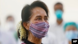 FILE - Myanmar leader Aung San Suu Kyi watches the vaccination of health workers at a hospital in Naypyitaw, Jan. 27, 2021.