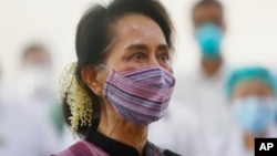 FILE - Myanmar leader Aung San Suu Kyi watches the vaccination of health workers at a hospital in Naypyitaw, Jan. 27, 2021.