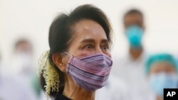 FILE - Myanmar leader Aung San Suu Kyi watches the vaccination of health workers at a hospital in Naypyitaw, Jan. 27, 2021.