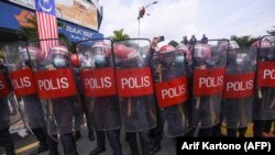 Polisi Federal Reserve Unit (FRU) memblokir jalan menuju gedung parlemen ketika anggota parlemen oposisi Malaysia berusaha berbaris di parlemen untuk memprotes penutupannya di Kuala Lumpur pada 2 Agustus 2021. (Foto: AFP/Arif Kartono)