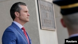 FILE - U.S. Defense Secretary Pete Hegseth stands at the entrance to the Pentagon, near Washington, Feb. 7, 2025.