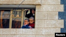 Children look at the scene of an explosion in Sana'a, Yemen, Jan. 22, 2015.