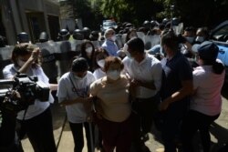 Vilma Núñez de Escorcia, activista de los derechos humanos, es custodiada por colegas ante una orden policial de retirarse del lugar.