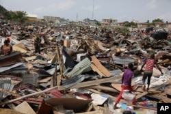 FILE - Residents salvage objects from houses demolished by government officials in Otodo-Gbame waterfront in Lagos Nigeria, March.18, 2017.