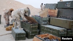 Islamic State fighters search weapon boxes in a Russian base in what is said to be Palmyra, Syria, in this still image taken from video uploaded to social media on Dec. 13, 2016.