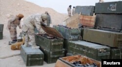 Islamic State fighters search weapon boxes in a Russian base in what is said to be Palmyra, Syria, in this still image taken from video uploaded to social media on Dec. 13, 2016.