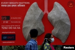 People pass by an installation of an artificial model of lungs to illustrate the effect of air pollution outside a hospital in New Delhi, India, Nov. 5, 2018.