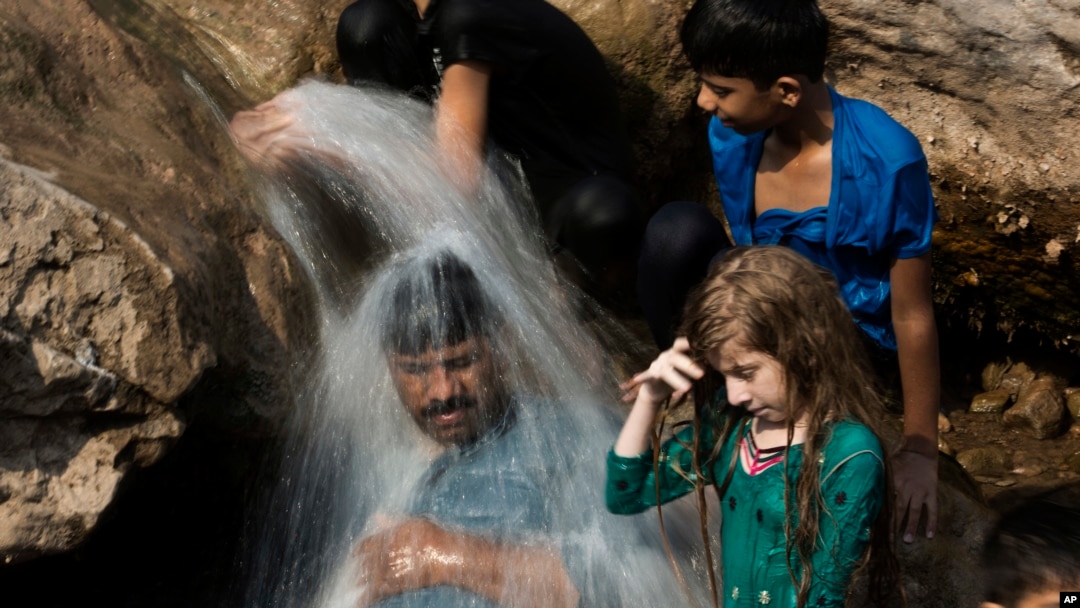 ARSIP - Sebuah keluarga mendinginkan diri di sungai selama gelombang panas yang melanda, di Islamabad, Pakistan, tanggal 30 Mei 2017. Kota Turbat di baratdaya Pakistan mencatat suhu setinggi 54 derajat Celsius pada bulan Mei (foto: B.K. Bangash/AP Photo)