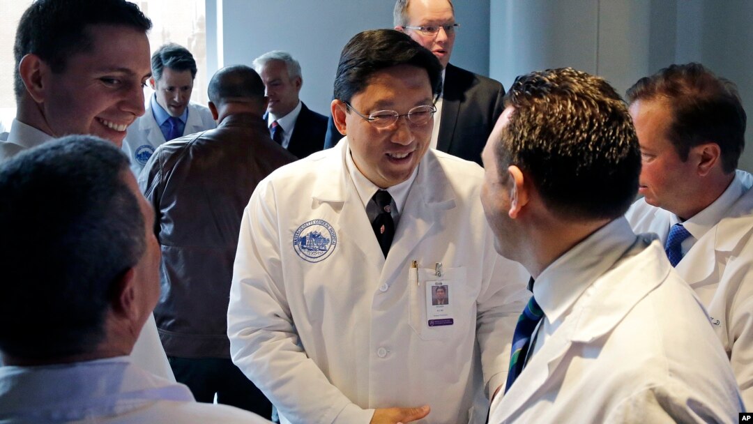 Dr. Dicken Ko, direktur program urologi Rumah Sakit Umum Massachusetts, berjabat tangan dengan anggota tim operasi usai konferensi pers di Boston mengenai transplantasi penis pertama di AS (16/5). (AP/Elise Amendola)