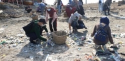 Sampah plastik nampak terdampar di pasir pantai Kenjeran, menjadi masalah bersama yang harus diselesaikan (Foto:VOA/ Petrus Riski).