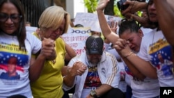 Personas rezan afuera de los tribunales del Palacio de Justicia por la liberación de quienes fueron detenidos durante la represión gubernamental tras las protestas contra los resultados de las elecciones presidenciales, en Caracas, Venezuela (Foto AP/Ariana Cubillos)