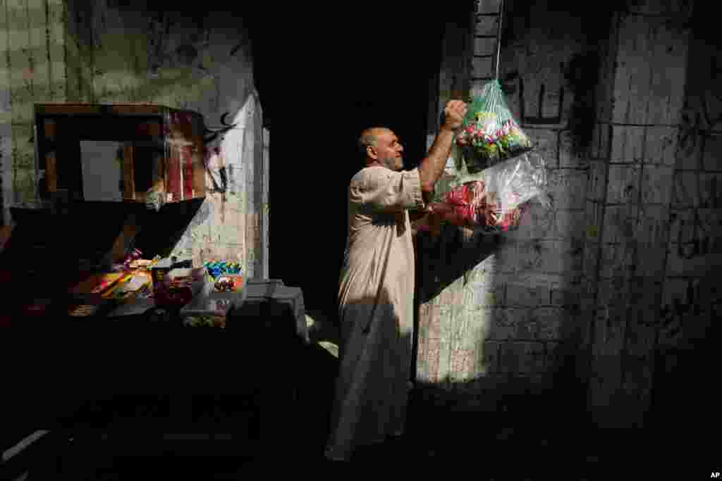 A Palestinian man works at his shop in Al-Shati refugee camp in Gaza City, June 19, 2014. 