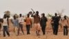 FILE - Nigerien farmers arrive to dig a trench to collect rainwater in the southern Zinder region, May 28, 2012. 