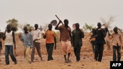 FILE - Nigerien farmers arrive to dig a trench to collect rainwater near the village of Tibiri in southern Zinder region, May 28, 2012. 