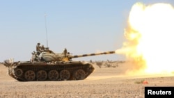 A tank operated by the government army fires at Houthi positions in the al-Labanat area, between Yemen's northern provinces of al-Jawf and Marib, Dec. 5, 2015.