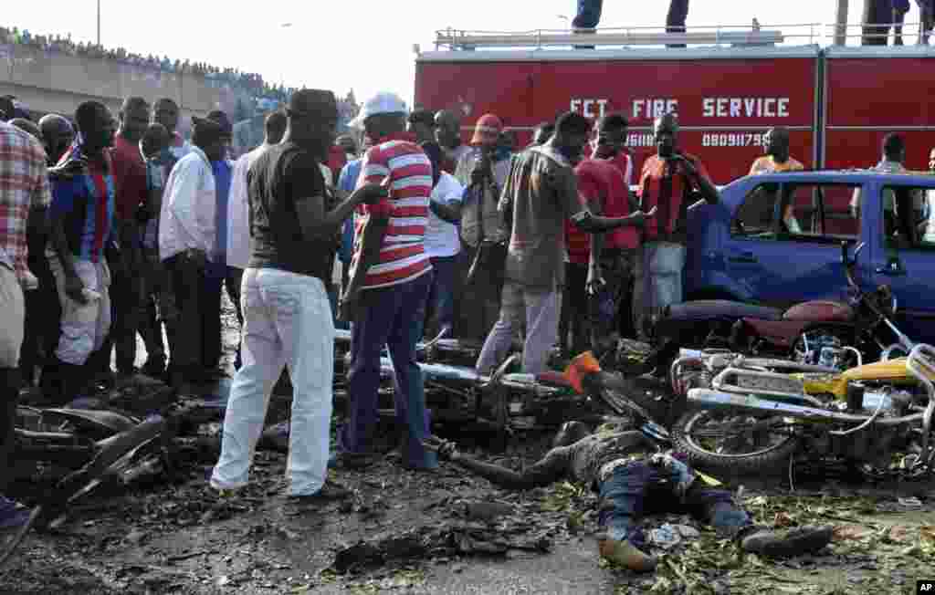 People gather at the site of a blast at the Nyanya Motor Park in Abuja, April 14, 2014. 