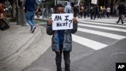 A boy holds a sign during a protest in downtown Los Angeles, California, May 29, 2020, over the death of George Floyd, who died in police custody on Memorial Day in Minneapolis.