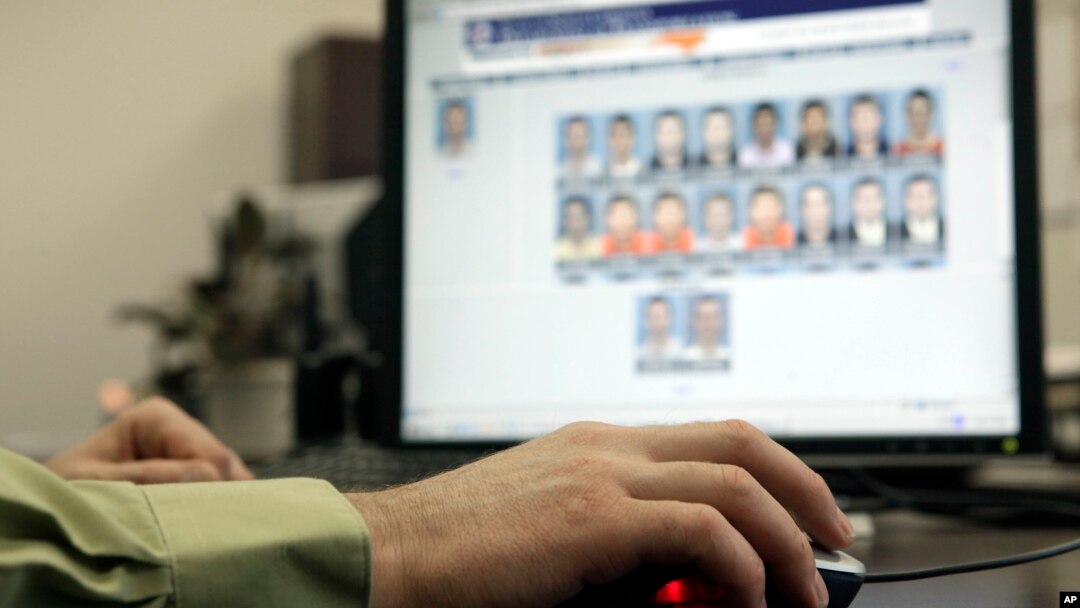 FILE - A law enforcement officer looks through photos in a facial-recognition system. Some critics consider use of the technology as discriminatory and lacking in proper oversight.
