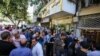 Iranians line up outside a currency exchange shop in Tehran in this recent photo published by Iran’s Fars news agency.