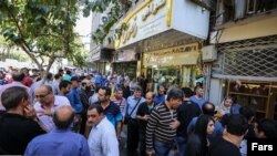 Iranians line up outside a currency exchange shop in Tehran in this recent photo published by Iran’s Fars news agency.
