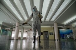 FILE - A health worker sprays disinfectant as part of preventative efforts against COVID-19, at the Okryu restaurant in Pyongyang, Oct. 21, 2020.