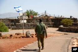 An Israeli soldier walks in an old military outpost, used for visitors to view the Israeli-controlled Golan Heights, near the border with Syria, May 10, 2018.