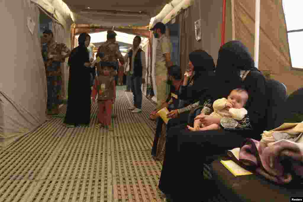 Syrian refugees wait for treatment at an Italian military hospital at the Al Zaatri refugee camp in the Jordanian city of Mafraq, near the Syrian border, June 25, 2013.