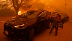 Residentes de Los Ángeles huyen ante el avance de incendio avivado por el viento