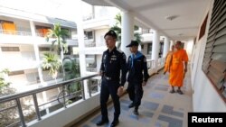 Policemen and Buddhist monks search for a fugitive Buddhist monk inside Dhammakaya temple in Pathum Thani province, Thailand, Feb. 17, 2017.