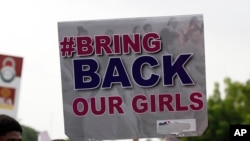 FILE - A sign carried by Nigerian protesters in Abuja calls on their government to rescue the kidnapped girls.