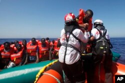 Migran Afrika yang terombang-ambing di atas perahu karet di Laut Mediterania, lepas Libya, diselamatkan oleh kapal MV Geo Barents MSF (Doctors Without Borders), di rute Mediterania tengah, Senin, 20 September 2021. (AP Photo/Ahmed Hatem)