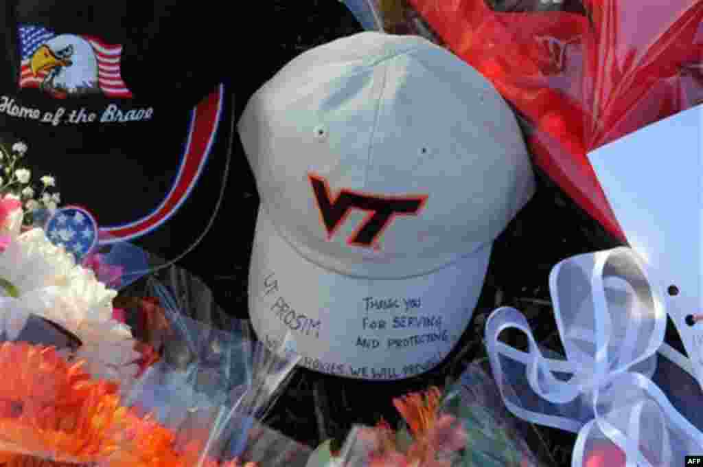 Flowers and words of thanks are left as a memorial in the parking lot where Virginia Tech police Officer Deriek Crouse was gunned down Thursday during a traffic stop on the campus of Virginia Tech in Blacksburg, Va., Friday, Dec. 9, 2011. (AP Photo/Don Pe