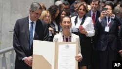 La presidenta electa de México, Claudia Sheinbaum, acompañada de su esposo Jesús María Tarriba, sostiene el documento oficial que la certifica como ganadora de las elecciones presidenciales al salir del Tribunal Federal Electoral, en Ciudad de México, el 15 de agosto de 2024.