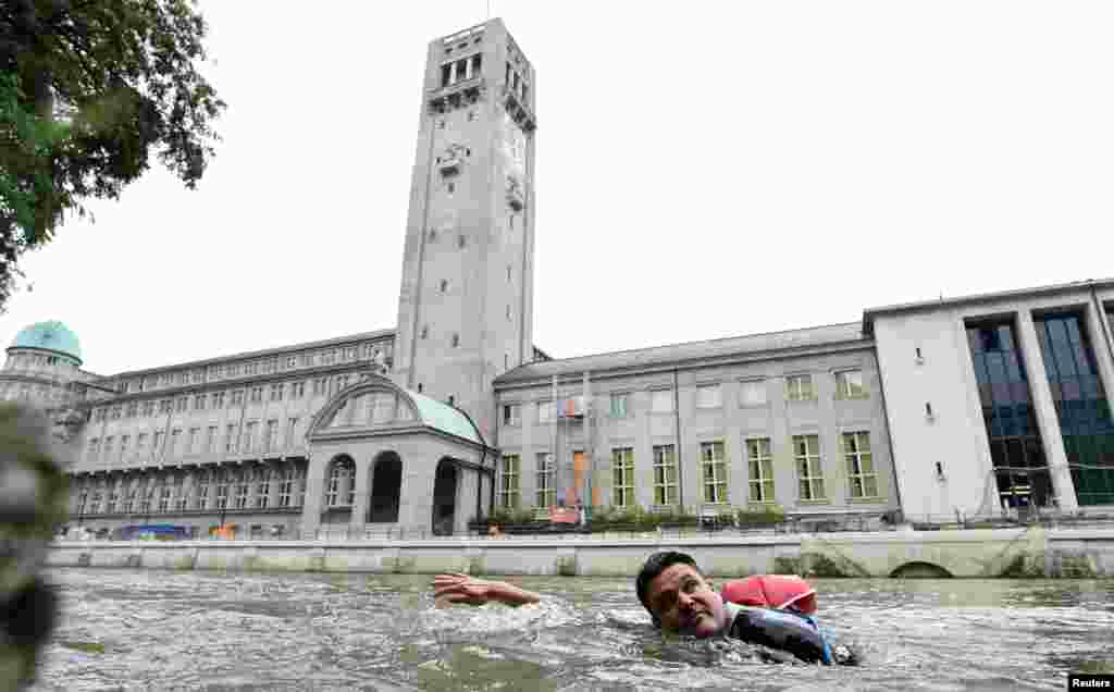 Benjamin David passes the Deutsches Museum as he swims from his home to his workplace along the Isar River in Munich, Germany.