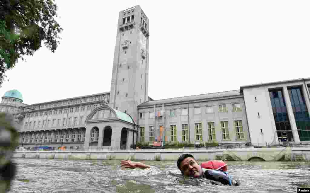 Benjamin David melewati museum Deutsches saat berenang dari rumahnya menuju kantornya melalui Sungai Isar di Munich, Jerman.