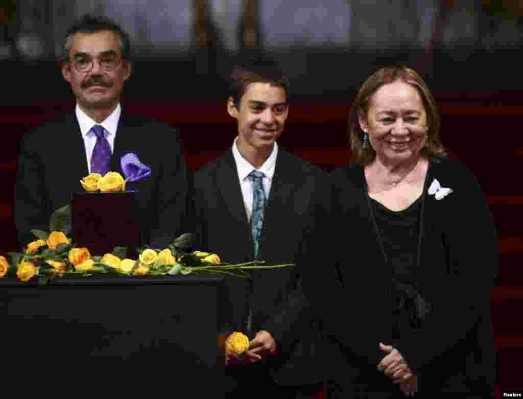 Mercedes Barcha (right), widow of late Colombian Nobel laureate Gabriel Garcia Marquez, her son Gonzalo Garcia Barcha (left), and her grandson stand next to an urn containing Garcia Marquez's ashes for public viewing in the Palace of Fine Arts in Mexico City, April 21, 2014.