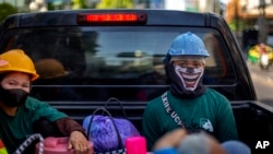 Construction workers wearing face masks travel in the back of a crew cab truck in Bangkok, Thailand, May 13, 2020.