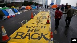 Người biểu tình tấm biểu ngữ với dòng chữ "Chúng tôi sẽ trở lại" tại bên ngoài trụ sở chính phủ ở Hồng Kông, 10/12/2014.