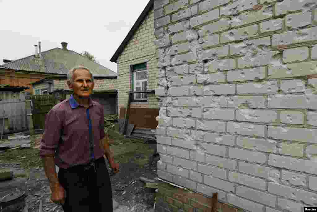 Yevgeni Kharkovski, 75, surveys the damage caused to his home by mortar shelling two nights ago, Slovyansk, Ukraine, May 12, 2014.