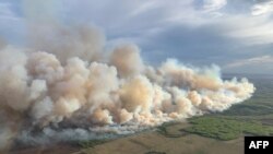 This aerial handout picture courtesy of the Alberta Wildfire Service, taken May 10, 2024, shows smoke from wildfires burning in the Grande prairie forest area, 4 kilometers east of the town of Teepee Creek, in Alberta, Canada.