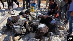 This photo provided by the Syrian Civil Defense White Helmets shows civil defense workers searching in the rubble after airstrikes hit in Khan Sheikhoun, in the northern province of Idlib, Syria, Sept, 24, 2017.