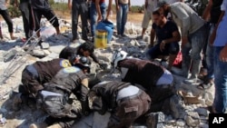 This photo provided by the Syrian Civil Defense White Helmets shows civil defense workers searching in the rubble after airstrikes hit in Khan Sheikhoun, in the northern province of Idlib, Syria, Sept, 24, 2017.