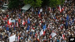 Ribuan orang berdemonstrasi di depan gedung parlemen di Warsawa, Polandia hari Minggu (16/7). 