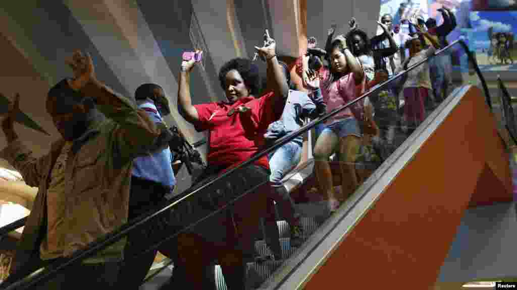 Civilians escape an area at the Westgate Shopping Mall in Nairobi September 21, 2013.