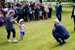 President Joe Biden stops outside at York High School and is greeted by a child and his mother, Monday, May 3, 2021, in Yorktown, Va.